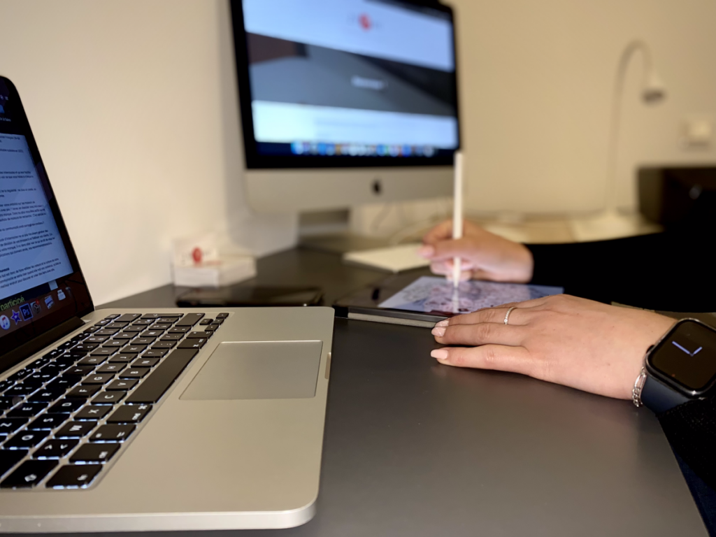 mains sur tablette en train de travailler, avec 2 ordinateurs à côté. 2 B Com', agence Communication digitale